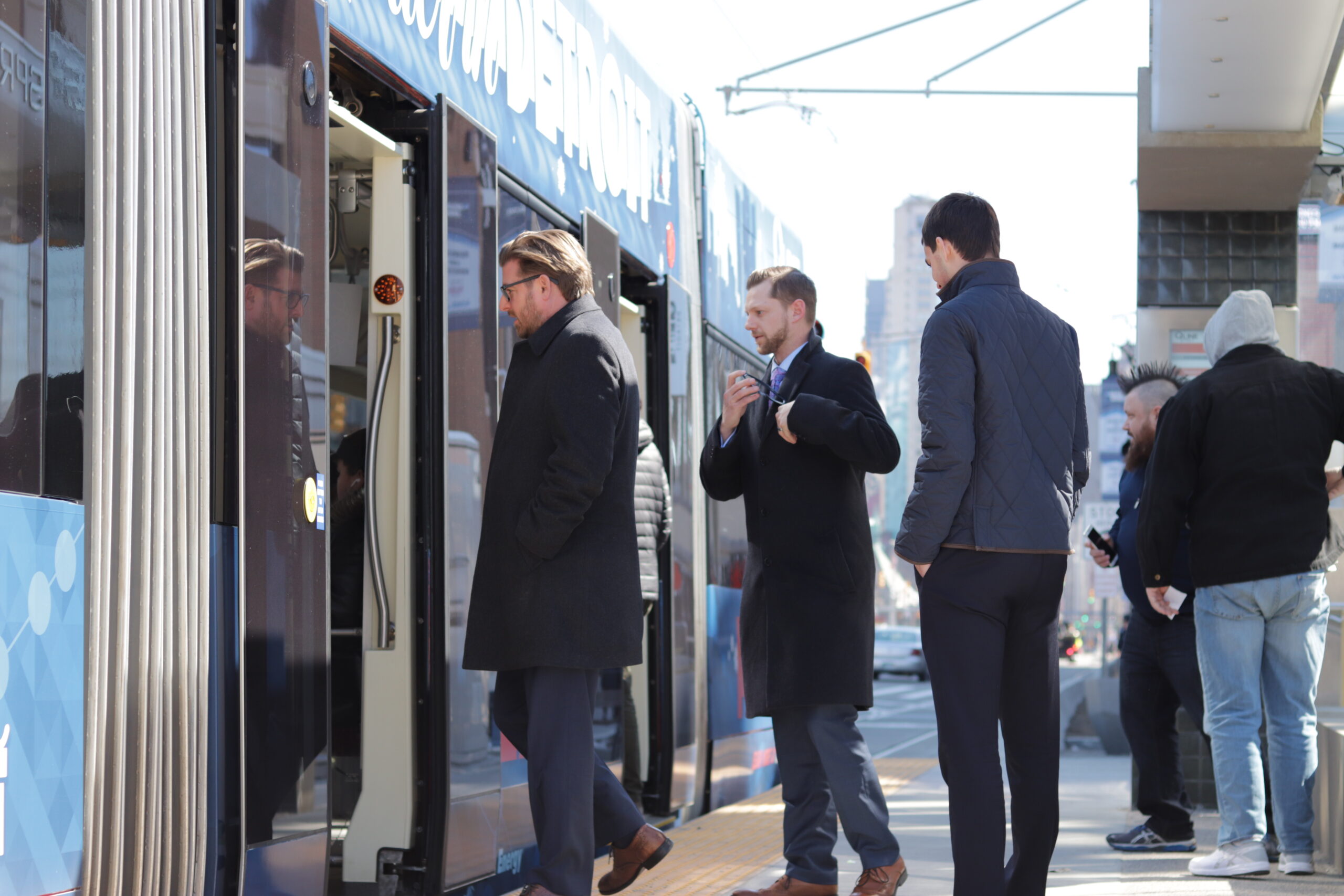 QLINE commuters dressed for cold weather boarding a bus