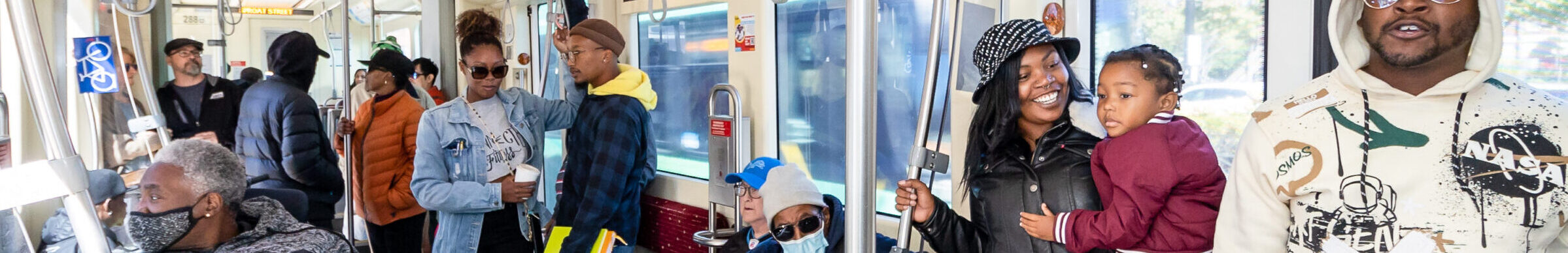 A bus full of people on a QLINE street car