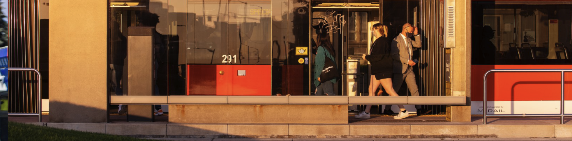 people walking next to the bus at a bus station